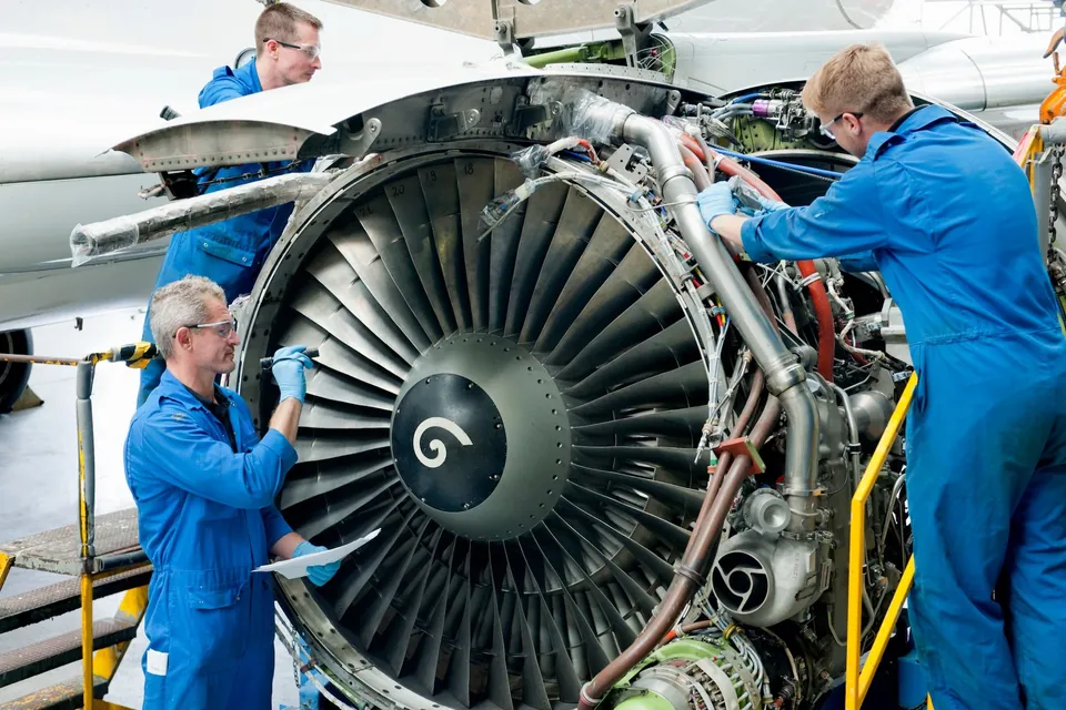 Technicians inspecting a commercial aircraft engine